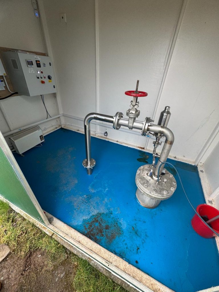 Original failing floor coating inside a borehole pump house