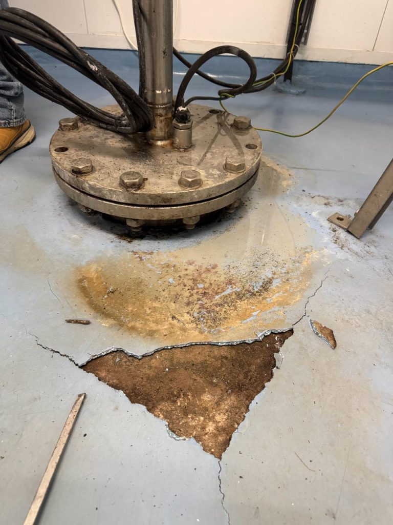 Blistered and failed floor coating around a wellhead