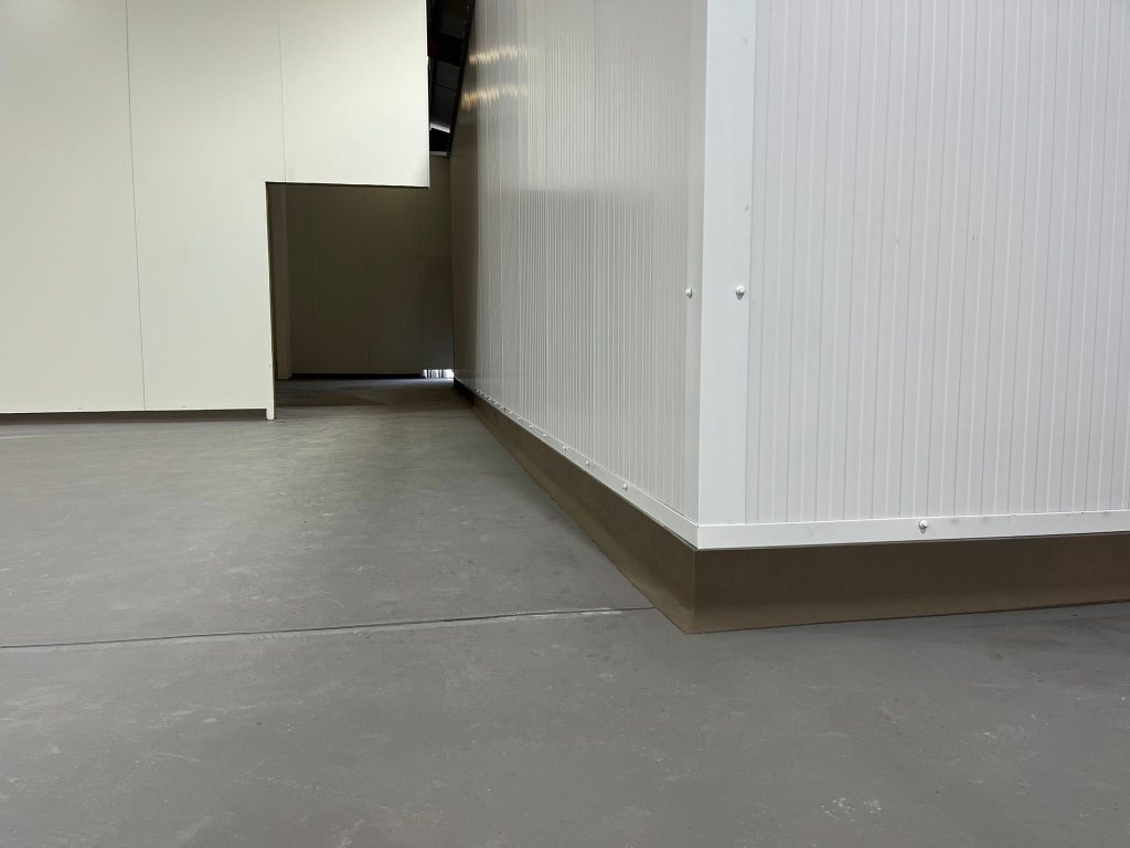 100mm-high polyurethane cove at the floor-to-wall junction